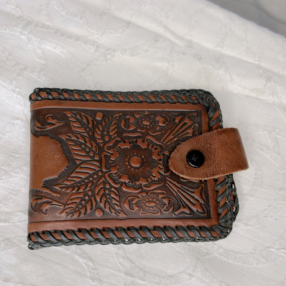 Vintage brown leather hand tooled bifold floral wallet. Woven braided edges.